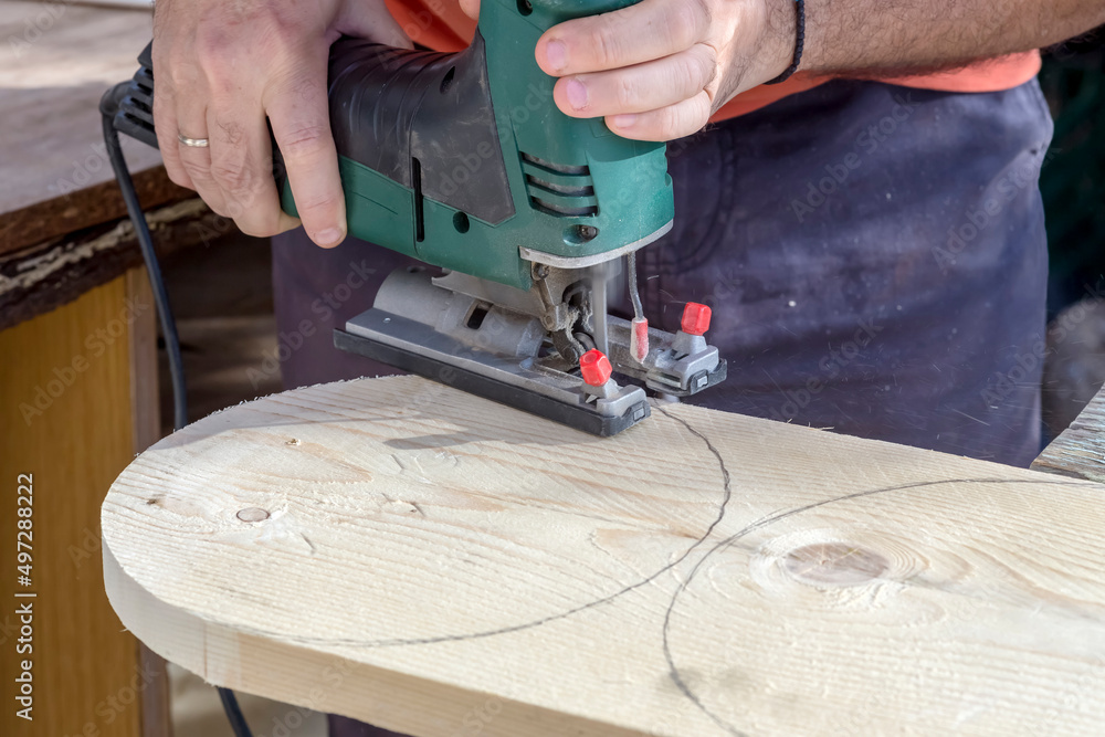 Men's hands with electric circular saw