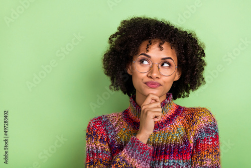 Photo of minded focused person arm chin look interested empty space isolated on green color background