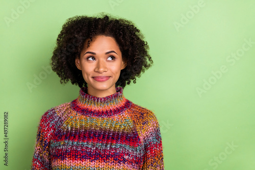 Photo of minded adorable girl look interested empty space imagine isolated on green color background