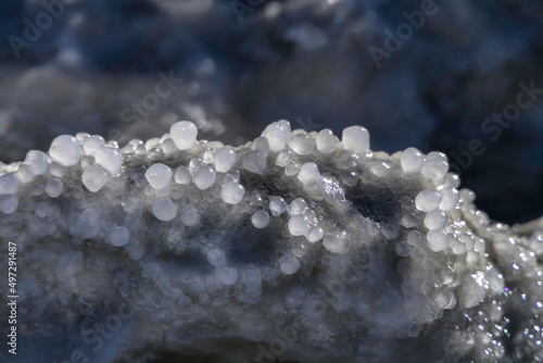 Round salt crystals of the Dead Sea closeup in the rays of the sun. Israel