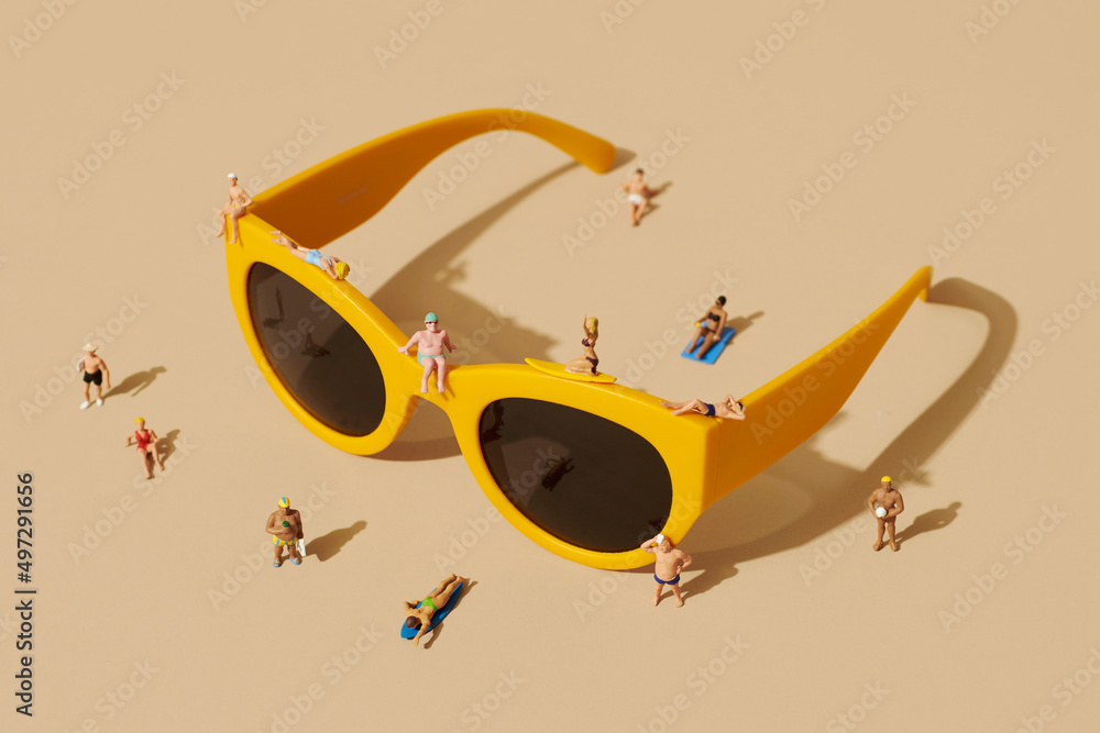 pair of sunglasses and miniature people - obrazy, fototapety, plakaty 