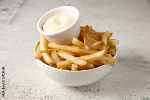close up shot of a white bowl of potato fries with mayo dip photo