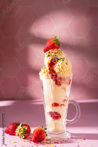 Vanilla ice cream milkshake garnished with fresh strawberry and colourful sprinkles