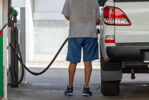 Man at fuel pump filling ute. photo