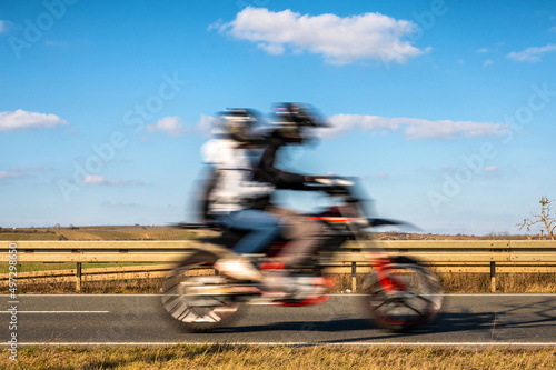 Motorradfahrer und Sozius auf einem Motorrad mit blauem Himmel zum Thema Transport und Freiheit