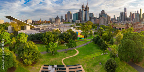 Aerial view of a green inner city park with a city skyline behind photo