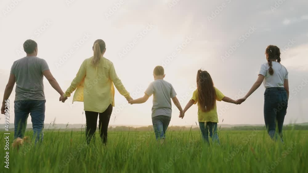 people in the park. happy family a silhouette walk in field fun. mom dad and daughters, son walk holding hands in park. happy family kid dream concept. parents and children walking back silhouette people in the park. happy family a silhouette walk in field fun. mom dad and daughters, son walk holding hands in park. happy family kid dream concept. parents and children walking back silhouette