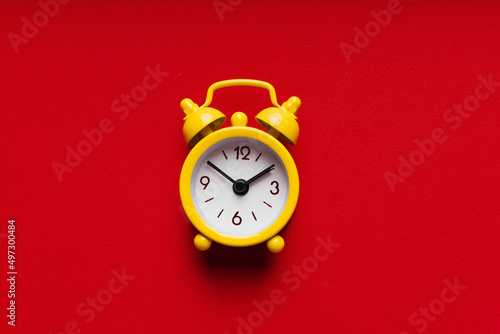 Yellow alarm clock on a red background close-up