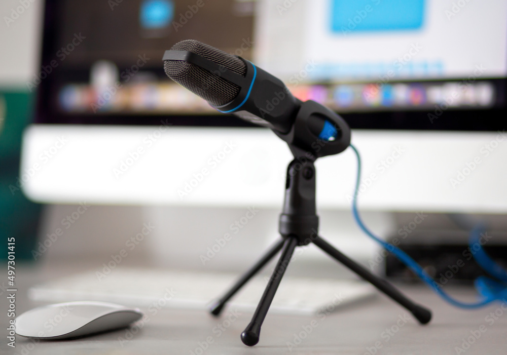 black microphone stands on a table next to a computer for sound recording black microphone stands on a table next to a computer for sound recording
