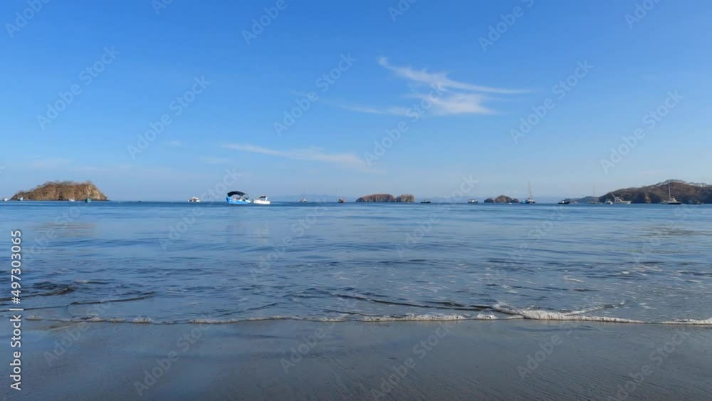 Woman walking on the beach at sunrise during summer vacation holidays, closeup of legs and feet in the sea water. Summer sunny mood, Costa Rica Woman walking on the beach at sunrise during summer vacation holidays, closeup of legs and feet in the sea water. Summer sunny mood, Costa Rica