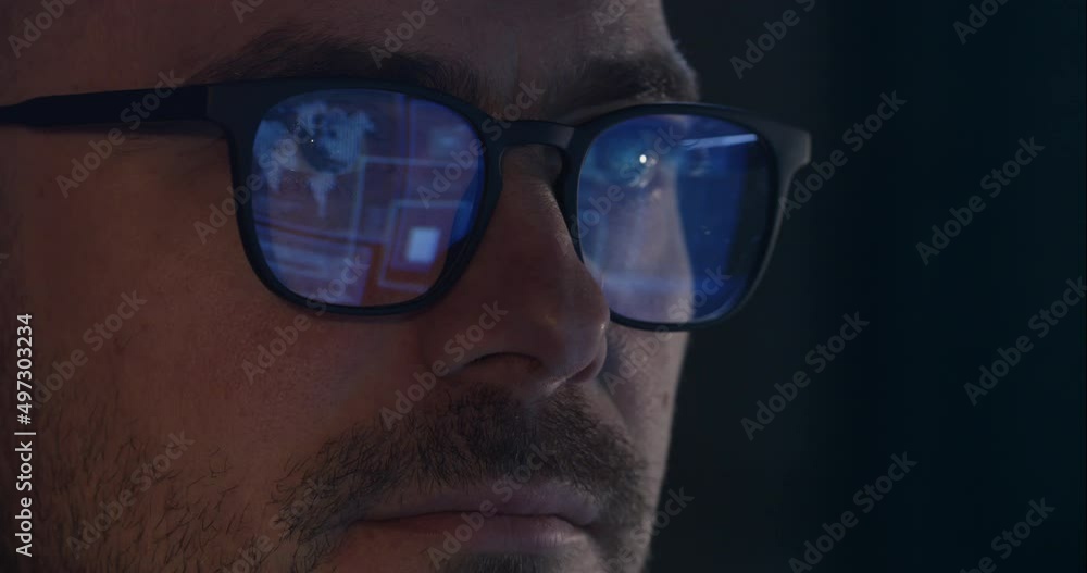 Reflection of information in glasses on the eyes, work in front of the monitor at night, a hacker breaks into the system. Portrait of a man with glasses at night. Reflection of information in glasses on the eyes, work in front of the monitor at night, a hacker breaks into the system. Portrait of a man with glasses at night.
