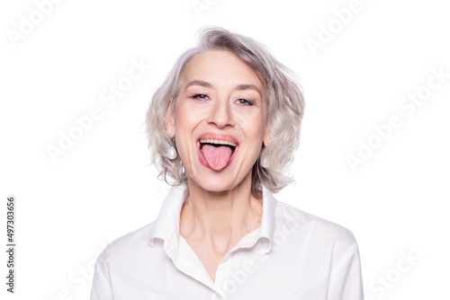 Shot of a beautiful mature woman having fun and teasing sticking out her tongue isolated on white background photo