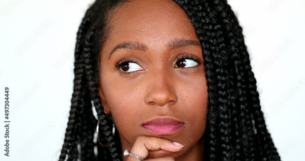 Pensive black African girl thinking, portrait teen daydreaming. Thoughtful contemplative young woman Pensive black African girl thinking, portrait teen daydreaming. Thoughtful contemplative young woman