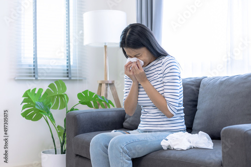Young Asian woman sick with a cold, She sneezed and had a runny nose.