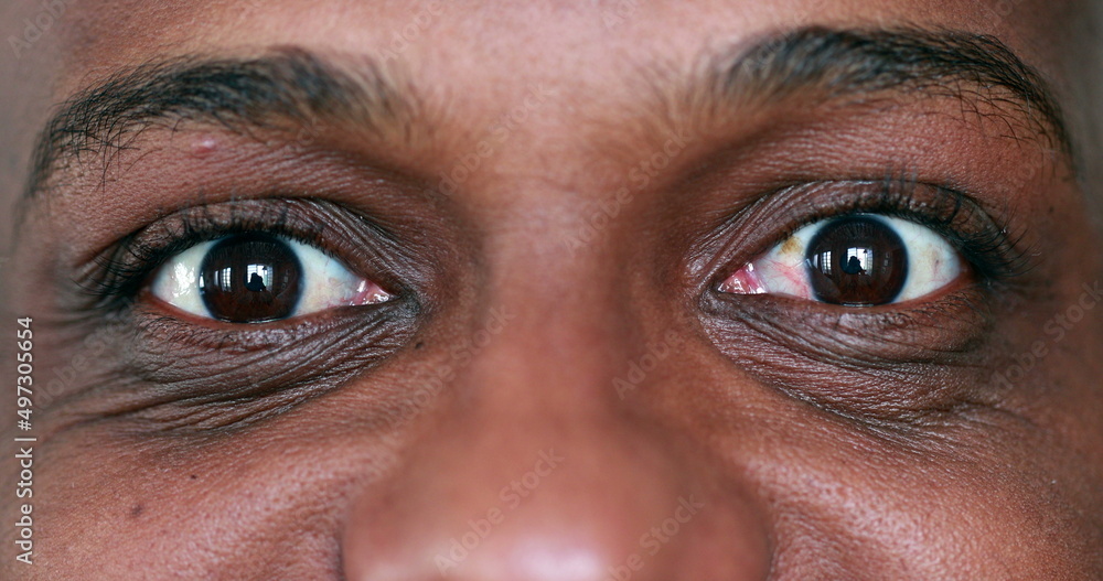 Extreme face close-up, macro eyes of black African man looking sideways Extreme face close-up, macro eyes of black African man looking sideways