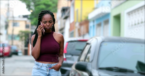 Black African woman talking on phone outside  candid mix race lady listening in conversation