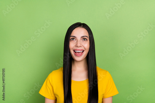 Photo of young pretty girl excited look empty space face reaction discount isolated over green color background