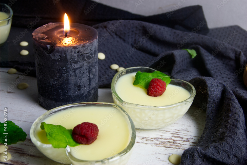 Pudding dessert with raspberry and mint on wooden floor. Near the candle. Pudding dessert with raspberry and mint on wooden floor. Near the candle.