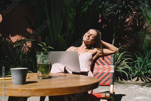 Happy millennial copywriter smiling during remote work - enjoying digital nomad, happy Caucaisan hipster girl with modern netbook computer keeping freelance lifestyle - technology and communication photo