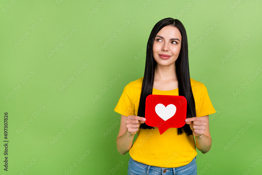 Photo of cheerful dreamy lady dressed yellow t-shirt holding heart like sign empty space isolated green color background Photo of cheerful dreamy lady dressed yellow t-shirt holding heart like sign empty space isolated green color background