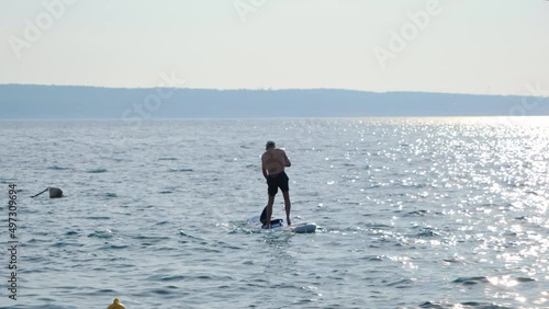 Man fall off paddleboard, slow motion. photo