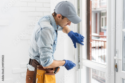 The worker installing and checking window in the house