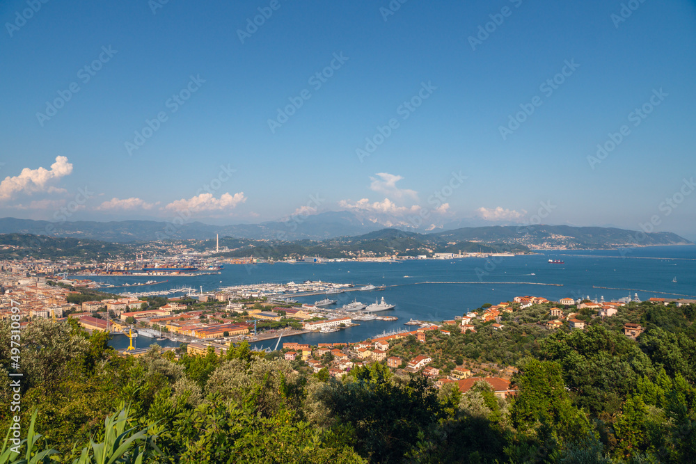 Sunny panoramic view of the city and the bay, port for ships from the distance. Tourism and transport. Rest and travel. Summe day.