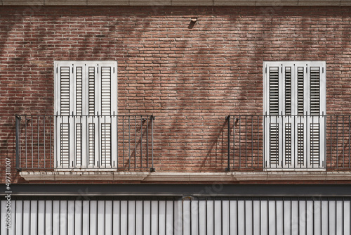Ventanas metálicas blancas en fachada de ladrillo visto