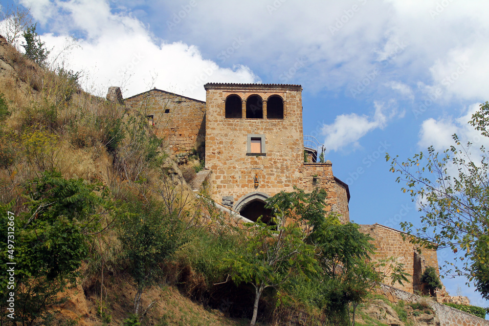 A traditional rock house on the cliff of a mountain with olive trees in Umbria A traditional rock house on the cliff of a mountain with olive trees in Umbria