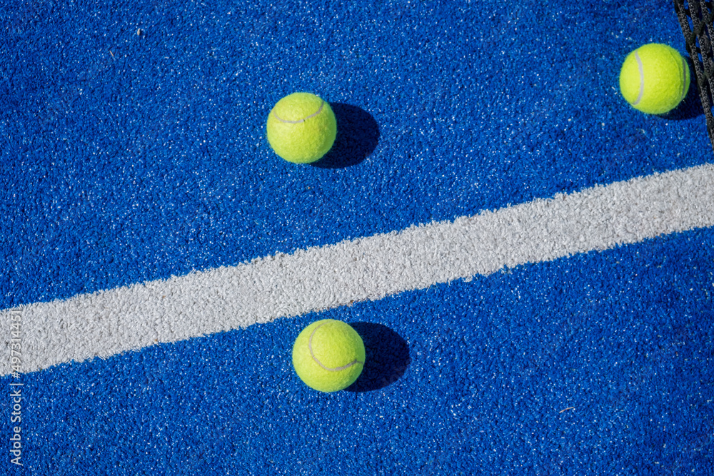 selective focus two paddle tennis balls on a blue paddle tennis court
