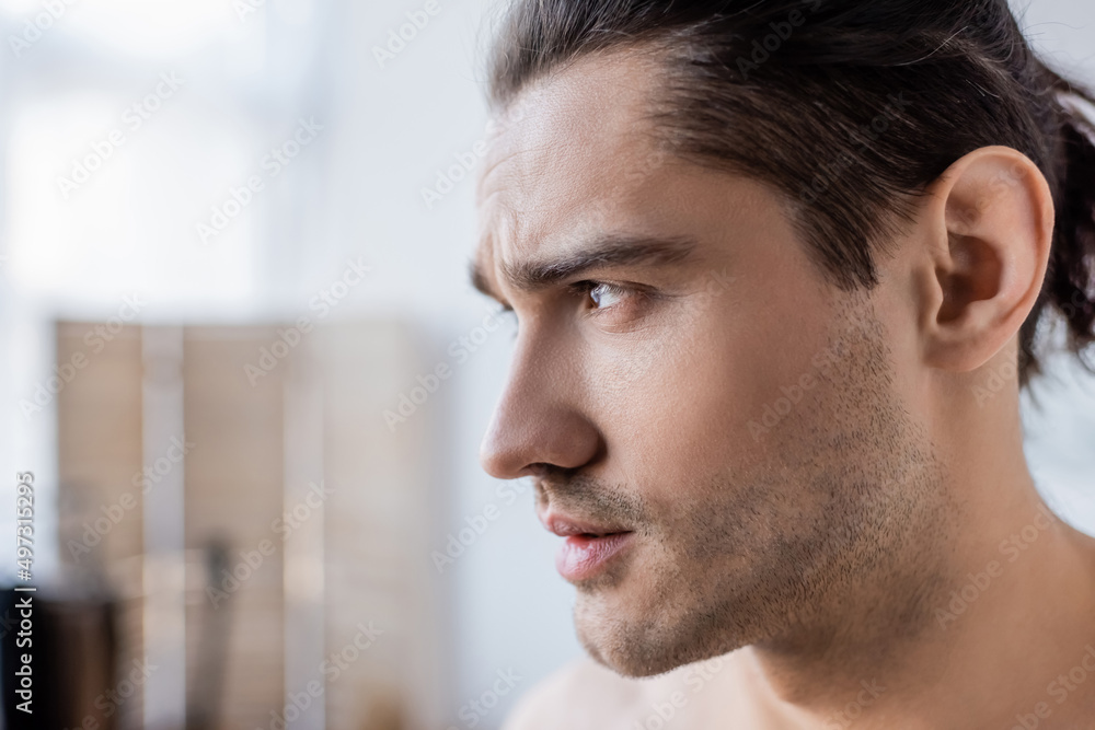 Obraz premium close up of man with long hair looking away at home.