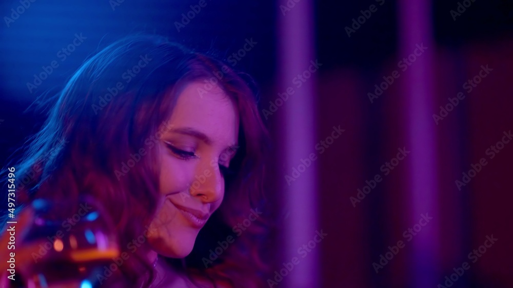 Close-up of a girl in a club drinking alcohol under a neon light. Night club Close-up of a girl in a club drinking alcohol under a neon light. Night club