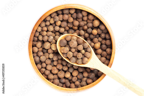 Spice Allspice (Jamaica pepper, Pimento) in wooden spoon diagonally and bowl on white background. Flat lay. Healthy eating concept