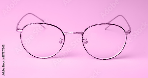 Woman trendy eyeglasses with round frames on violet purple background. High quality photo