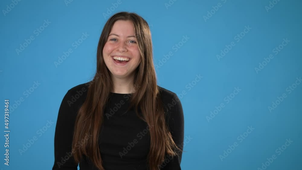 Portrait of happy smiling young brunette woman 20s thumbs up, wears black shirt isolated on plain blue background copy space studio portrait. People emotions lifestyle concept Portrait of happy smiling young brunette woman 20s thumbs up, wears black shirt isolated on plain blue background copy space studio portrait. People emotions lifestyle concept