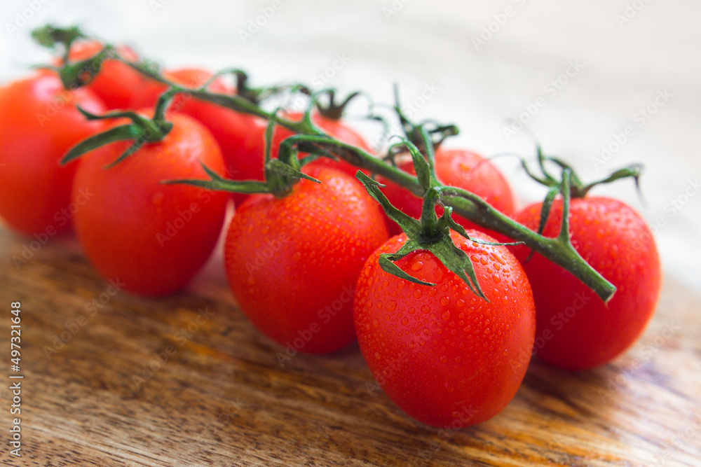 Fresh red cherry tomatoes on a branch, close-up. Growing vegetables, organic food concept. Fresh red cherry tomatoes on a branch, close-up. Growing vegetables, organic food concept.