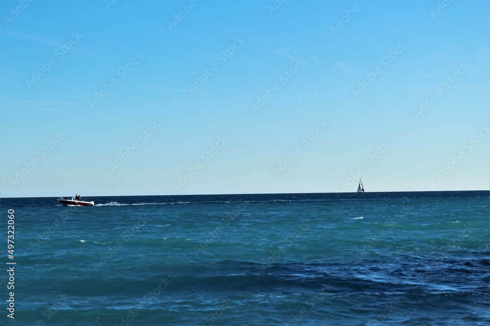 A motor boat and sailboat out at sea in the Mediterranean (Cagnes-sur-Mer, France)