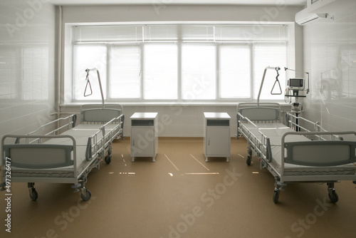 Fototapeta Naklejka Na Ścianę i Meble -  Recovery room with beds and comfortable medical equipment. Interior of an empty hospital room. Clean and empty room with a bed in a new medical center