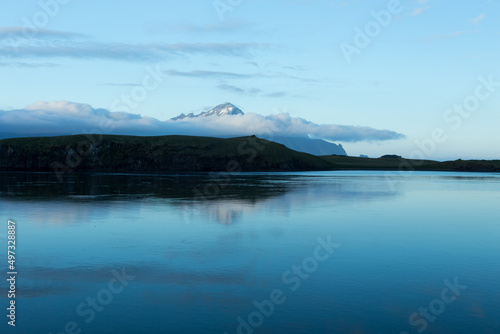 Mountains with low clouds seen across a fjord during a late evening blue hour with mountains in soft focus, Hofn, Iceland