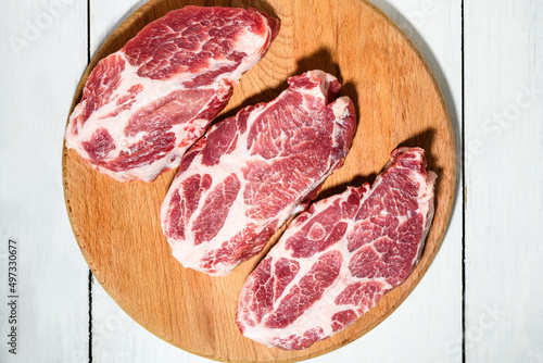 Sliced raw pork meat on wooden surface, top view