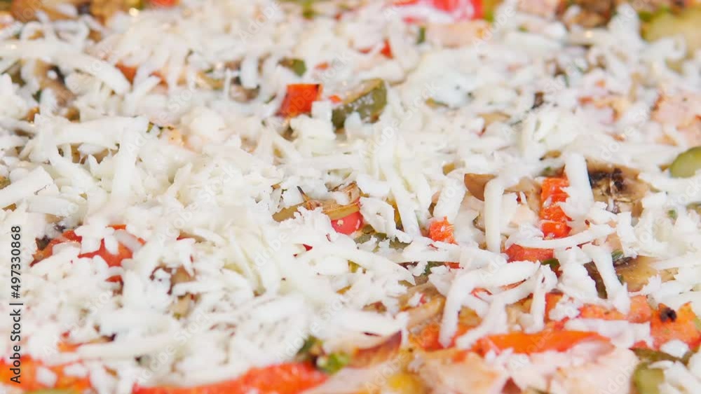 Sprinkles cheese on pizza close-up. The process of cooking. Selective focus Sprinkles cheese on pizza close-up. The process of cooking. Selective focus