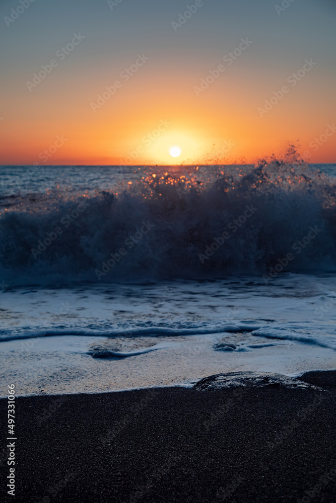 The sea wave. Sunset in the sea. The power of the elements.