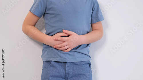 little boy experiences abdominal pain. Baby's medication and health concept. Stomach ache. Suffering a young child. Food poisoning, abdominal pain. Health problems in children. photo