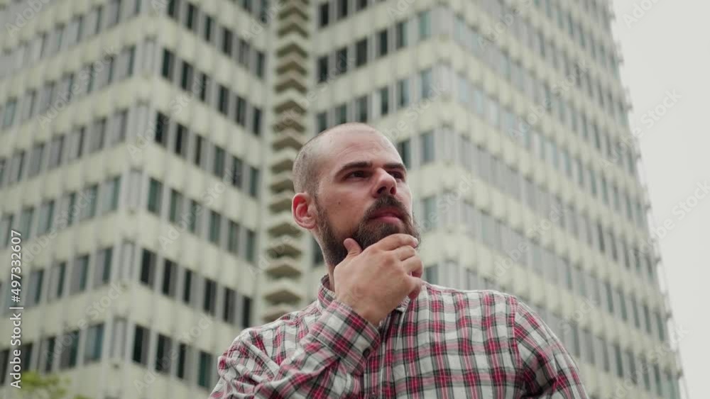 Handsome Spanish man portrait. Brutal latin guy posing outdoor, male bearded model looking in camera close-up, standing in street on multistoried building background. Handsome Spanish man portrait. Brutal latin guy posing outdoor, male bearded model looking in camera close-up, standing in street on multistoried building background.