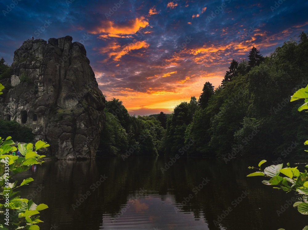 Image of the Externsteine ​​in the Teutoburg Forest photographed from the pond, where the sky is reflecting