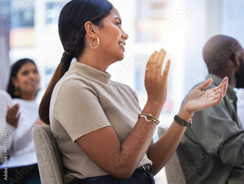 Upskilled and ready. Shot of a young woman clapping hands in a meeting at work in a modern office. photo
