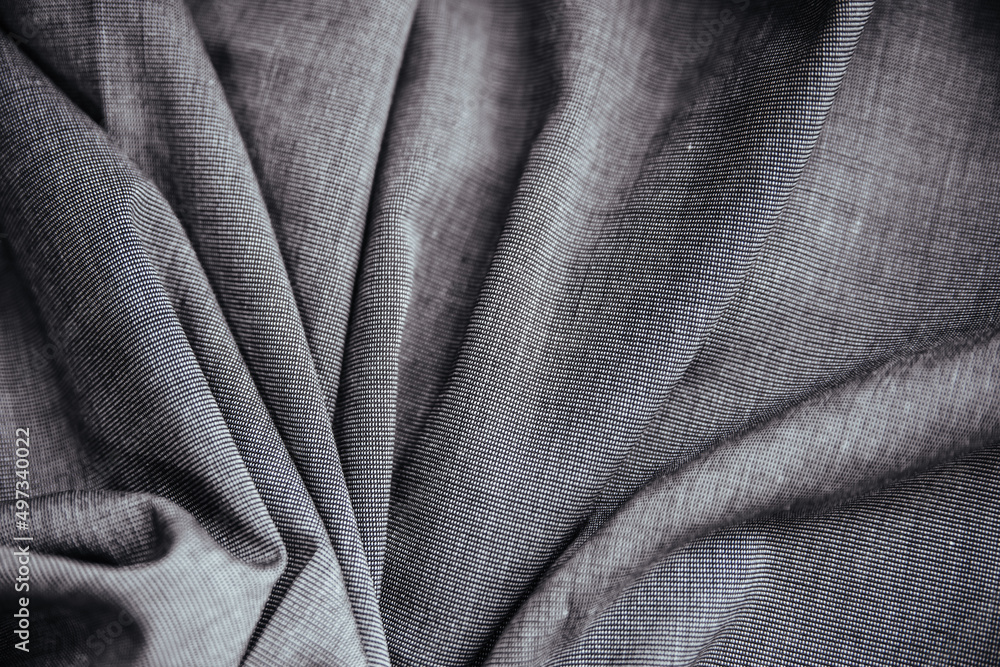 Fototapeta premium Gray wrinkled draped fabric. Sewing material is on the table.