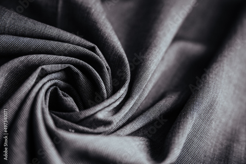 Gray wrinkled draped fabric. Sewing material is on the table.