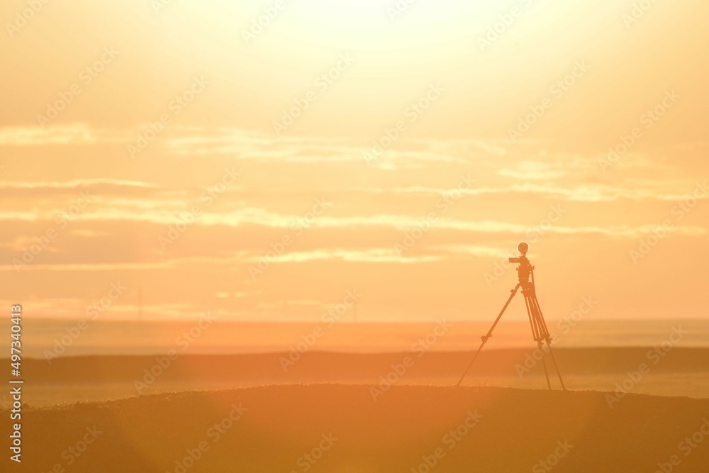 video camera on a tripod in the steppe at dawn
