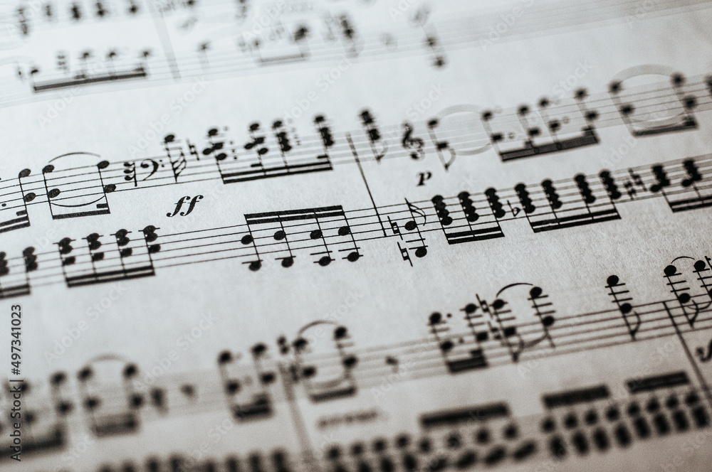 Macro photo of complicated sheet music in bass and treble clef for piano with Italian notation Macro photo of complicated sheet music in bass and treble clef for piano with Italian notation